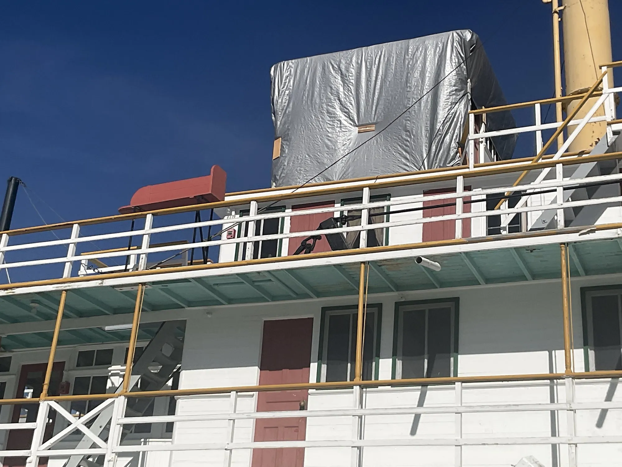 Texas deck with the pilothouse wrapped in a protective cover and the buff stack beside it