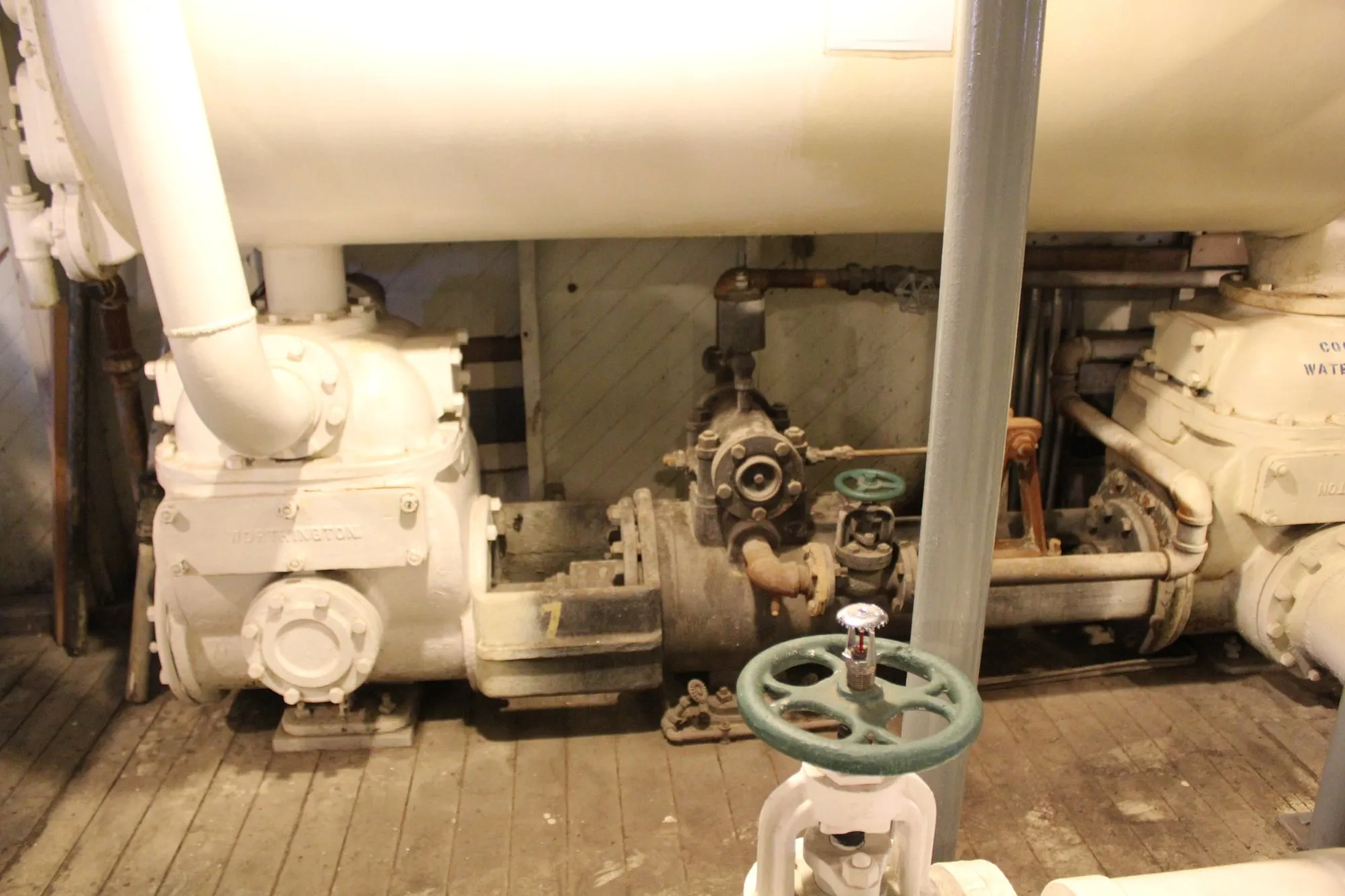 Two pumps and a valve handwheel beneath the large horizontal shell