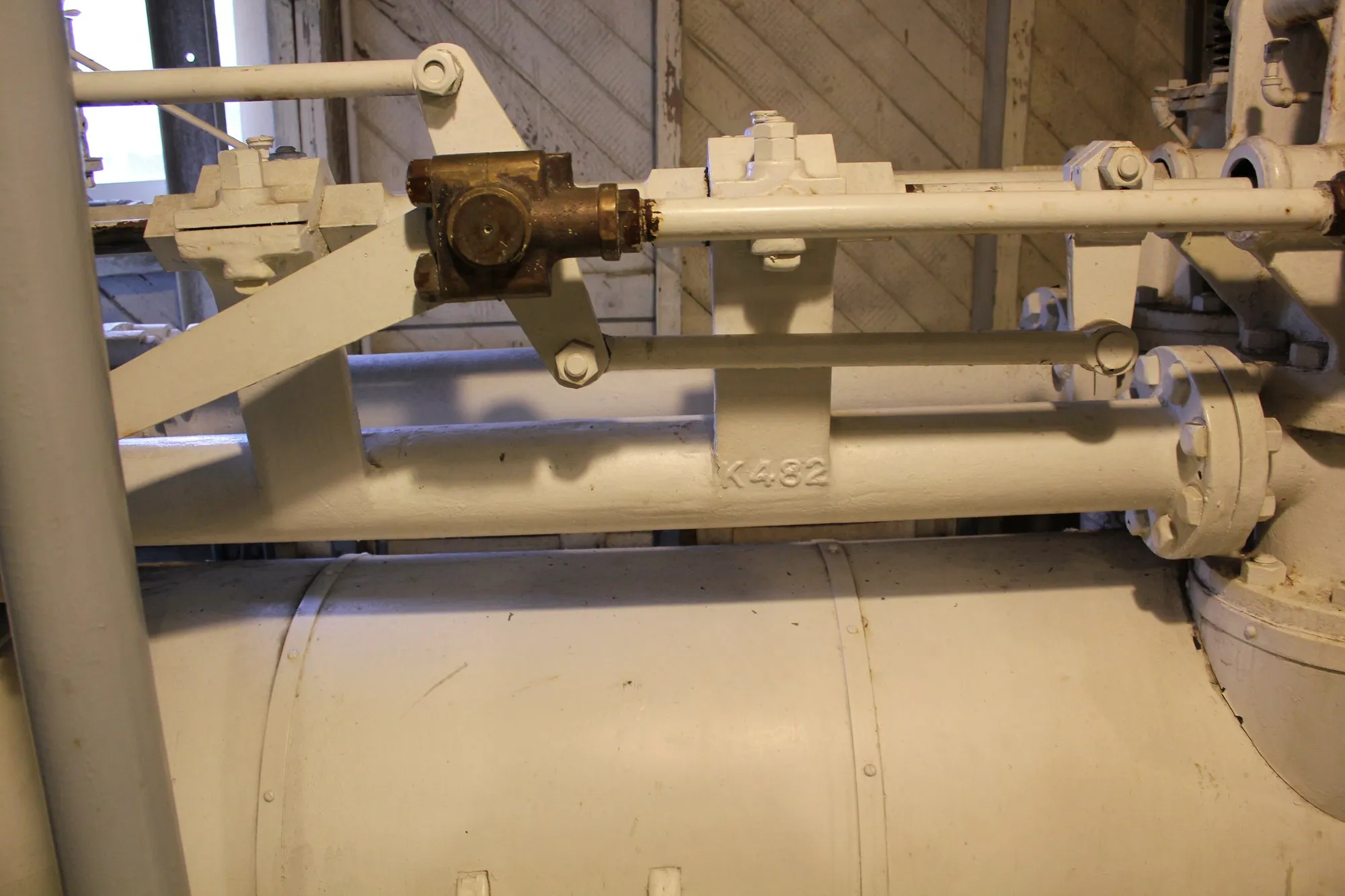 Valve gear rods and brackets running along the top of a cylinder, with the casting mark K432