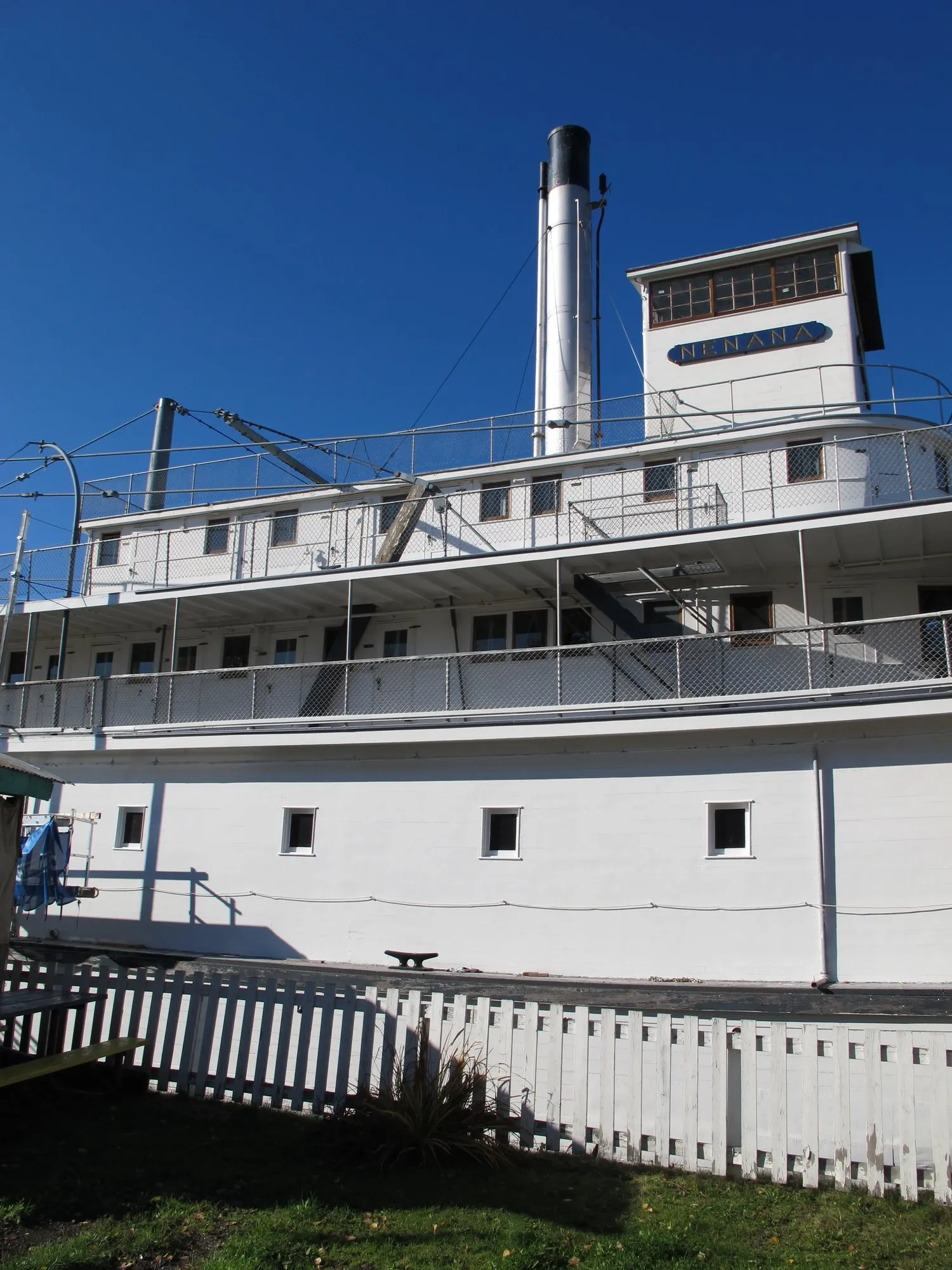White superstructure, pilothouse and stack against a deep blue sky