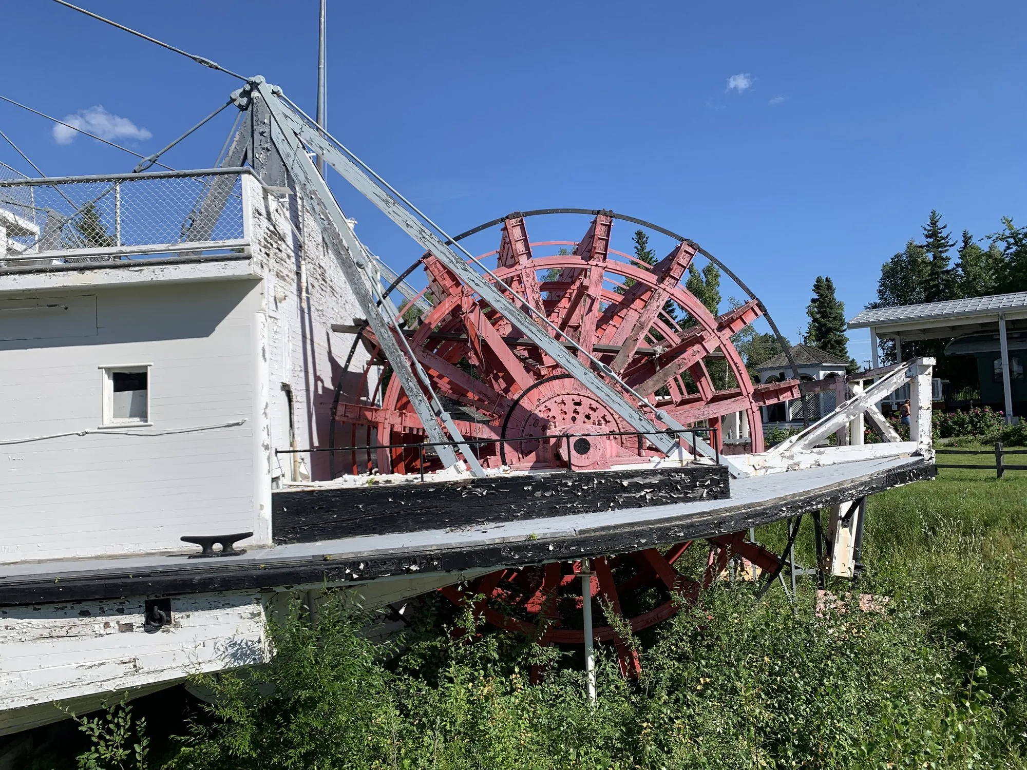 Sternwheel and its supporting frame seen from the side, summer grass below
