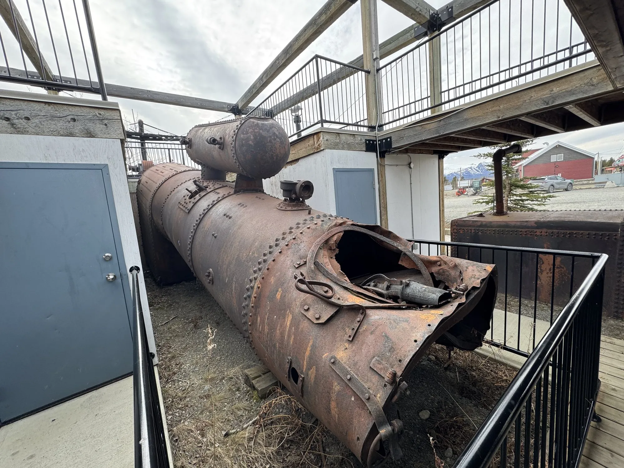 The boiler remains seen from the opposite end, inside a railing
